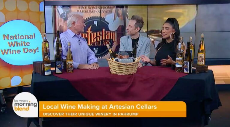 Three people discuss wine at a table with bottles; Local Wine Making at Artesian Cellars appears on screen.