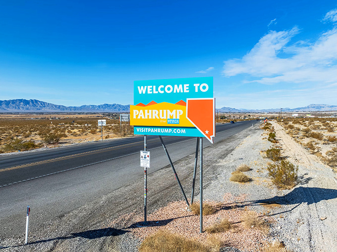 Roadside sign reads Welcome to Pahrump, Nevada with desert landscape and mountains in the background.