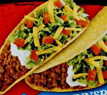Two hard shell tacos filled with ground beef, lettuce, diced tomatoes, shredded cheese, and sour cream.