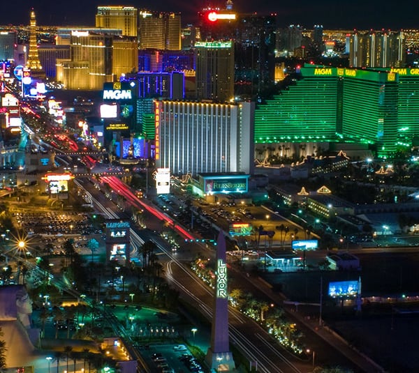 Aerial view of the Las Vegas Strip at night, with brightly lit hotels and casinos.