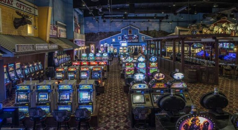 Rows of colorful slot machines and casino games inside a western-themed gaming area with a barn backdrop.